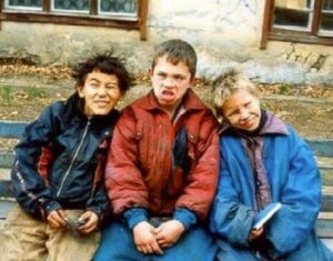 La gentilezza silenziosa del custode scolastico cambiò molte vite — e, anni dopo, cinque SUV neri si fermarono davanti alla sua vecchia roulotte.