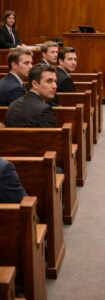 Le pesanti porte dell’aula di tribunale si aprirono con un lungo cigolio metallico che attraversò il silenzio come una lama.